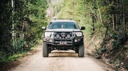 The stock Toyota Tacoma is a reliable, practical rig. But you’ll want some aftermarket upgrades if you want to do more off-road. Two of our editors recently emerged from the overlanding rabbit hole with two totally transformed trucks. They’re rugged, safe, capable, and totally overkill for the majority of us. But, hey, we can dream! Presenting 11 kickass parts to trick out the aspiring 4x4er’s ultimate ride.
Photo: ARB Deluxe Bull Bar ($1,160)
Built from steel, the Bull Bar replaces your flimsy factory bumper and adds important protection to the front of your truck. Why it’s needed: you won’t ruin your radiator if you accidentally brush a tree or hit an animal, and it still fully integrates with your airbags and headlights. It also acts as a platform for extra gear, like a winch.