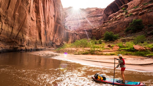 This May, five adventurers pushed off below the bridge at Highway 12 in southern Utah to navigate a 100-mile stand-up paddleboard first descent on the Escalante River, which drains into Lake Powell. The caravan, composed of Dylan Brown, Morgan Tilton, Jordan Curet, Morgan Smith, and Aaron Kloer—all seasoned outdoor explorers but novice boaters—made hundreds of hook turns for six days through Grand Staircase-Escalante National Monument’s soaring Navajo sandstone. The gorge reached heights of more than 1,000 feet and greeted the crew with boulder-strewn whitewater.
Here, Morgan Tilton takes us through a few of Dylan Brown's favorite shots from the trip.
Photo: Tilton admiring one of the many stunning horseshoe bends in a series of progressively taller, more pronounced 180-degree curves near the halfway point on the Escalante. She rode the inflatable Hala Gear Straight Up, which is durable and stable, with fully removable fins and well-placed reinforced stainless D-rings for strapping down gear.