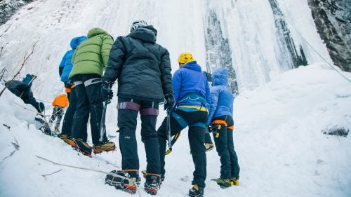 Climbers looking up at Genesis One as their instructor shows them how to spot weaknesses in the ice.