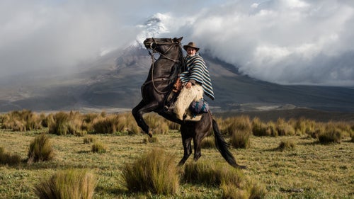 Guido Villamarín showing respect to the still-active Cotopaxi volcano in Ecuador on his way to a local roundup.