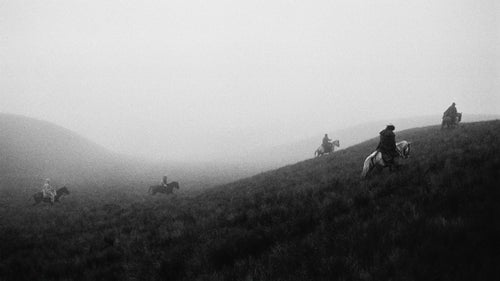Ecuadorian cowboys, called chagras, rounding up wild horses on a foggy, wet afternoon.