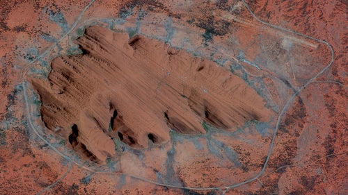 Uluru, or Ayers Rock, is a large sandstone formation in the Northern Territory of Australia. The monolith—towering 1,141 feet high and around 2.2 miles wide—is a sacred site to the Aboriginal people of the area who first settled there 10,000 years ago. While the first Australian tourists arrived at Uluru in 1936, annual visitor numbers rose to over 400,000 by the year 2000. Increased tourism at the site provides regional and national economic benefits, but also creates an ongoing challenge to balance conservation, cultural values, and visitor needs.