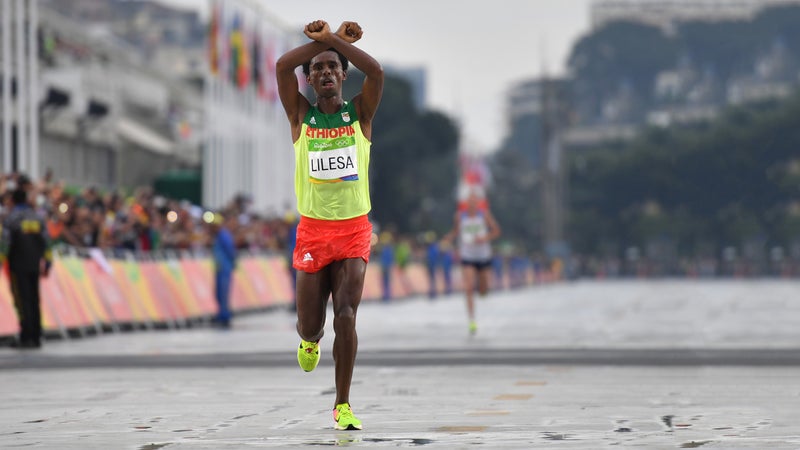 Ethiopia's Feyisa Lilesa (silver) crosses the finish line of the men's marathon at the 2016 Olympic Games in Rio.