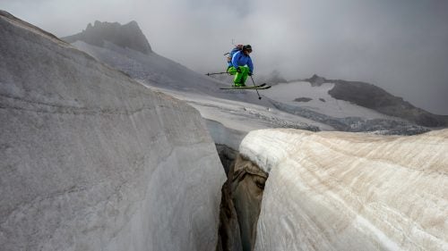 Ever since I could walk, I’ve been in the mountains of Washington. Throughout my life, I’ve observed the retreat of their glaciers. Recently, I set out to record these places as they are, turning them into a time capsule for future generations. As a bonus, the project pushes me to look outside the typical routes to those less-visited corners just beyond my doorstep.
Since 2014, I’ve completed 134 of the 213 named glaciers in Washington, and it will take me another five to ten years to finish. Each glacier can require as much as a week to get to because snowfall and foul weather can disrupt travel in the Cascades. It has taken hundreds of missions so far and will take a hundred more, depending on how I link them together.
When I was a teenager, my twin brother, Josh, and I decided to ski every month of the year. I’ve been doing that for 220 months straight, and I’ve seen the snowpack cycle swell through fall and winter and melt into spring and summer. Throughout those years, it was easy in midwinter to see the normal blanket of snow that covers the mountains. But in summer, when the snowpack is at its minimum, I’ve seen a steady retreat year by year.
Photo: Adam Roberts launches a ballsy air over a crevasse on Paradise Glacier, Mount Rainier National Park, Washington.