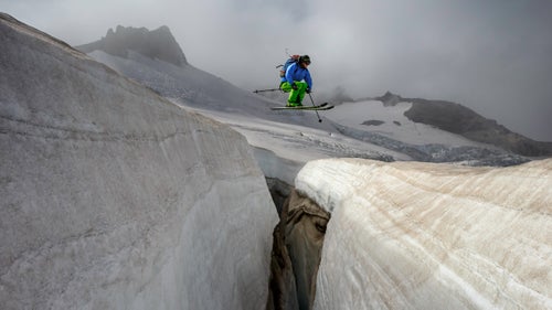 Ever since I could walk, I’ve been in the mountains of Washington. Throughout my life, I’ve observed the retreat of their glaciers. Recently, I set out to record these places as they are, turning them into a time capsule for future generations. As a bonus, the project pushes me to look outside the typical routes to those less-visited corners just beyond my doorstep.
Since 2014, I’ve completed 134 of the 213 named glaciers in Washington, and it will take me another five to ten years to finish. Each glacier can require as much as a week to get to because snowfall and foul weather can disrupt travel in the Cascades. It has taken hundreds of missions so far and will take a hundred more, depending on how I link them together.
When I was a teenager, my twin brother, Josh, and I decided to ski every month of the year. I’ve been doing that for 220 months straight, and I’ve seen the snowpack cycle swell through fall and winter and melt into spring and summer. Throughout those years, it was easy in midwinter to see the normal blanket of snow that covers the mountains. But in summer, when the snowpack is at its minimum, I’ve seen a steady retreat year by year.
Photo: Adam Roberts launches a ballsy air over a crevasse on Paradise Glacier, Mount Rainier National Park, Washington.
