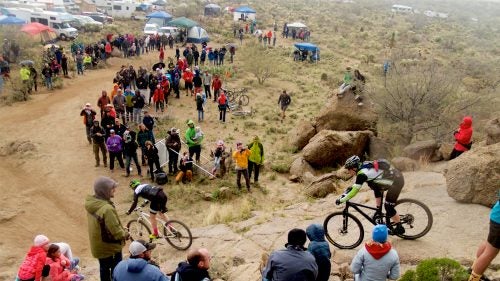 24 Hours in the Old Pueblo, one of the country’s great 24-hour races, went off this President’s Day weekend, complete with thundering rain, a rowdy party, and four former members of the U.S. Postal Service Pro Cycling Team. On a quiet patch of rock and dirt outside Tucson, Arizona, nearly 2,000 riders and even more spectators gathered on February 18 for a round-the-clock, relay-style mountain bike competition on a 16-mile loop through the desert.
Team WEDU24 caught attention for its star-studded roster—Lance Armstrong, George Hincapie, Christian Vande Velde, and Dylan Casey. But they didn’t come with major expectations of winning. Instead, like most other competitors, they were intrigued by the party and a chance to ride for 24 hours straight, and they found exactly what they were looking for. Photographer Maria Nasif followed the crew through a rainy night.
Photo: A crowd gathered at a popular spectator section called the Rock Drop just before the skies opened up and soaked the course.