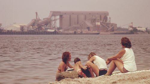 Children play in the water of Lake Charles, directly across from the Olin Mathieson Chemical Plant in Louisiana.