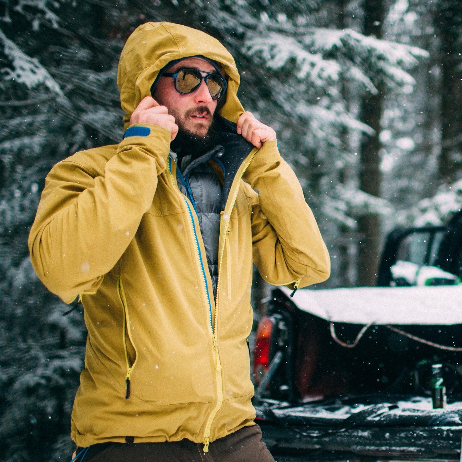 Young man with ski in the snow forest standing near the car