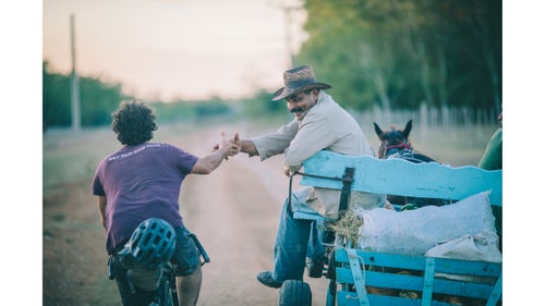 On January 1, my wife, Virginia, and I joined our riding buddy Joe Cruz and set out to cycle across Cuba using mainly rugged dirt tracks, horse paths, and mountain roads. As with all of our bikepacking trips, the objective was to dig ourselves into the backwaters of our new surroundings and find out what the country is really like. We began on the eastern coast, in the city of Santiago de Cuba, and rode through three mountain ranges, countless fishing and farming villages, and finally into Viñales, on the opposite coast. Ultimately, we discovered a country full of warm people, quirky eccentricities, and natural beauty.
Here, Logan Watts, the editor at Bikepacking.com, shares a selection of images from their 860-mile, 20-day trip.
Photo: Many times, folks insisted on stopping us to hear where we were from and where we were going. Other times, they just reached out their hand for a friendly shake.