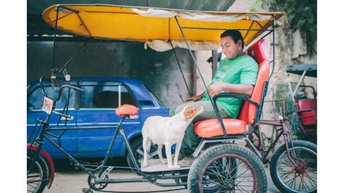 After flying into Havana, we waited for our Santiago shuttle at a bike taxi stand. This gentleman had a co-pilot.