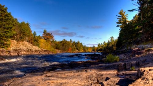 #10 Menominee River
Michigan, Wisconsin
The Menominee, a 115-mile-long river that courses through the forests of Michigan’s Upper Peninsula, is an outdoorsman’s paradise. It’s ideal for rafting and home to plenty of smallmouth bass, trout, and sturgeon. Too bad, then, that Aquila Resources, a Canadian mining company, is currently seeking permits to begin operations along the Menominee’s banks. The mining would rely on cyanide to extract and process ore and would discharge wastewater directly into the river, according to American Rivers. Groundwater, local animals, and even Lake Michigan would all be threatened if acid mine discharge were to seep into the earth, the group warns.
