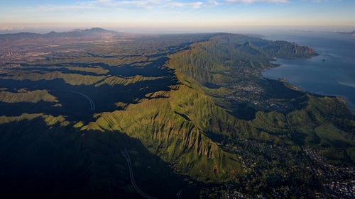 Early morning light fills the cracks of the Ko’olau Mountain Range. The conspicuous linear crest is the western rim of the extinct Ko’olau volcano and represents the route to traverse the entire range.