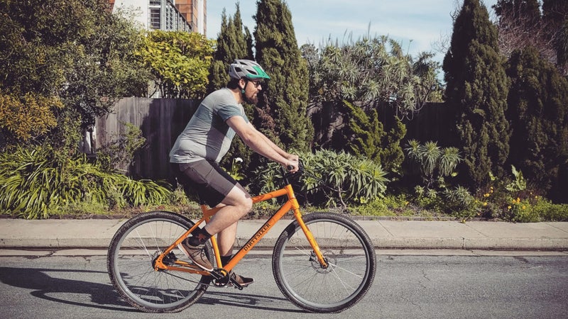 The bigger wheels work by allowing the tall rider to sit between the wheels, in the middle of the bike, rather than cantilevered back over the rear axle, as on a sized-up frame on normal tires. This benefits weight distribution, comfort, and stability, but also allows for a higher bottom bracket, and subsequently longer cranks.