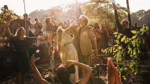 Thronged mostly by cheering strangers, the couple briefly exchanged vows, shotgunned two beers, and walked off into the literal sunset.