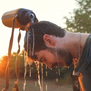 hiker Man dropping fresh water on his head