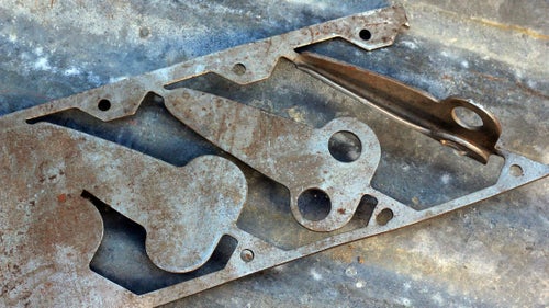 Angle-Iron Die
In his business memoir, Let My People Go Surfing, Yvon Chouinard credits genius machinist Harold Lefler for designing the dies that allowed him to keep up with growing demand for his pitons. This is a plate of chromoly steel that would be fed into a progressive die in the Lefler Tool and Die machinery in Burbank, California. The way Julio Varela, Chouinard Equipment pioneer and now owner of Ojai Clothing, explained it, chromoly plates were fed into the die much like a roll of paper on an old dot-matrix printer. A succession of stamps punched out the metal progressively until the piton took shape, and a press stamped the angle iron into the precise width and taper. The ends were sheared off, and the pitons were dipped into a black-oxide bath and then heat treated, creating Chouinard pitons’ distinctive black hue. Varela remembers Chouinard showing up barefoot and shirtless at Lefler’s Burbank facility to pick up boxes of pitons to ship to his customers. “He loved Yvon,” Varela said. “He’d do anything for him.”