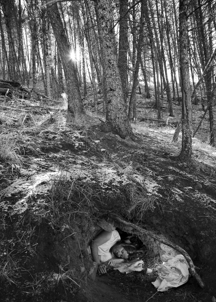Linda curls up in an abandoned wolf den in Yellowstone National Park.