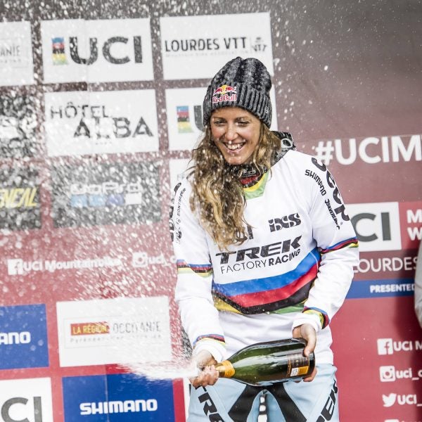 Rachel Atherton stands on the podium at UCI DH World Cup in Lourdes, France.