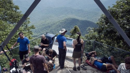 THE APPALACHIAN TRAIL, NEAR FRANKLIN, NORTH CAROLINA – 08/21/2017: Hikers and tourists congregate at Albert Mountain Fire Tower on the Appalachian Trail, on the center line of the path of eclipse totality. Hundreds of walkers and day-trippers walked into the woods at Albert Mountain to witness a total eclipse. Forest Rangers closed entrance roads and monitored numbers trying to access the Fire Tower denying access to the area as the number of spectators grew through the day. CREDIT: Spike Johnson for Outside Magazine.