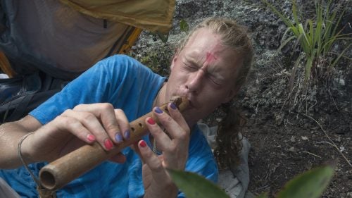 THE APPALACHIAN TRAIL, NEAR FRANKLIN, NORTH CAROLINA – 08/21/2017:
Bjorn Parramoure, 31, from Gainesville, Florida waits for the solar eclipse beneath Albert Mountain Fire Tower along the Appalachian Trail in North Carolina. He’s camped at Albert Fire Mountain, on the centerline of eclipse totality to wait for the event. With a homemade recorder he welcomes the eclipse. CREDIT: Spike Johnson for Outside Magazine.