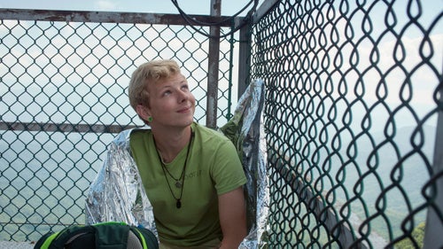 THE APPALACHIAN TRAIL, NEAR FRANKLIN, NORTH CAROLINA – 08/21/2017: Joseph Ellzey, 24, from Mississippi watches the eclipse from the top of Albert Mountain Fire Tower on the Appalachian Trail in North Carolina. He traveled to Albert Mountain early in the morning to secure a spot at the top of the crowded tower, and sat wrapped in a foil blanket ready to witness the eclipse from the highest point in any visible direction. CREDIT: Spike Johnson for Outside Magazine.