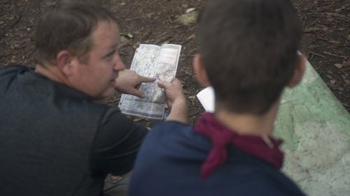 THE APPALACHIAN TRAIL, NEAR FRANKLIN, NORTH CAROLINA – 08/21/2017: Simon Farr (right), from Asheville, North Carolina, ponders maps of the area with a section hiker at Carter Gap, five miles south of the center line of eclipse totality. As local families and tourists pour into the area, die-hard hikers plan for quieter, and harder to reach areas to witness the eclipse. Farr works on trail maintenance in the Southern Appalachians, and is hiking towards his own secret hiking area. “I have these old ordinance maps,” he said “there’s places on these that don’t show on other maps.” CREDIT: Spike Johnson for Outside Magazine.
