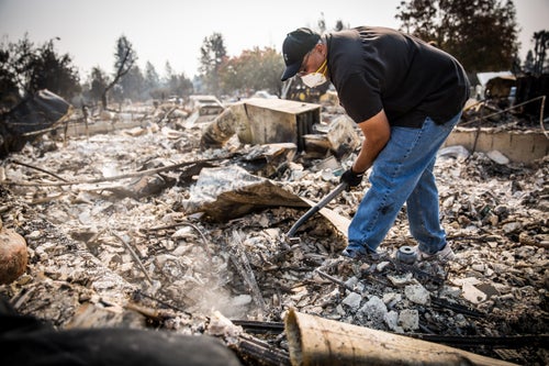 Chris Parker looks for valuables in the remains of friend Bob Stewart's house in the Coffey Park neighborhood of Santa Rosa, California on October 13, 2017. As of Friday night, the Tubbs Fire had burned more than 2,000 homes in the Santa Rosa area.