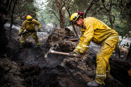 Firefighters Wes Daniels, left, and Milo Schroder, right, mop up on the Tubbs Fire near Calistoga, California on October 13, 2017. As of Friday night, the Tubbs Fire had burned more than 2,000 homes, 35,000 acres and was 44% contained.