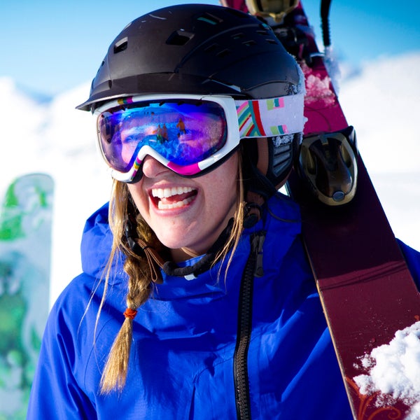 Waist up photo of couple walking towards camera with the skis on.