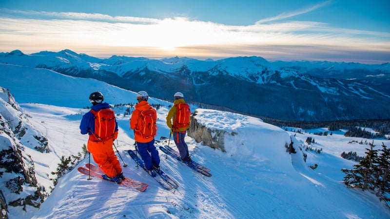 Skiers Kalen Thorien, Josh Daiek and Alexis Godbout look out over the edge of a chute at Whistler Blackcomb