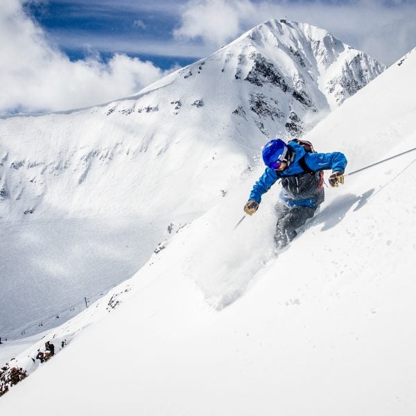 Steve Lowry skiing above the Pinnacles with Lone Peak in the distance. Big Sky Resort, Montana