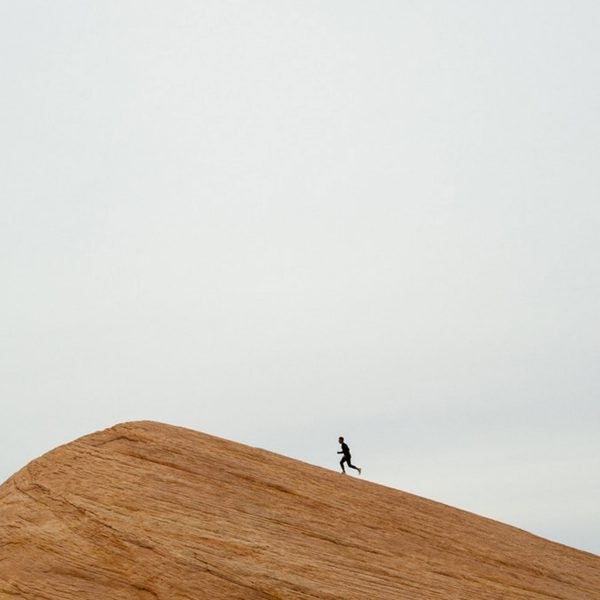 Man running up sandstone rock