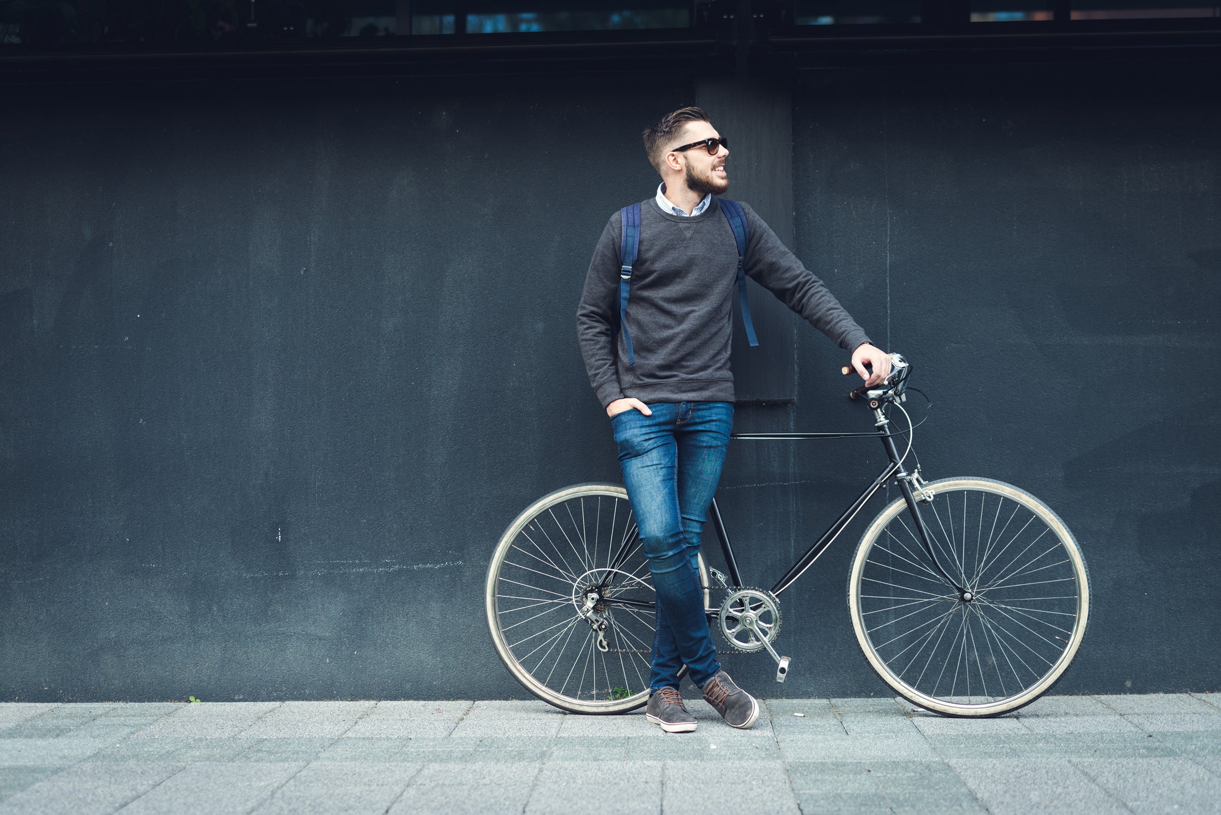 guy wearing a school backpack near a bike