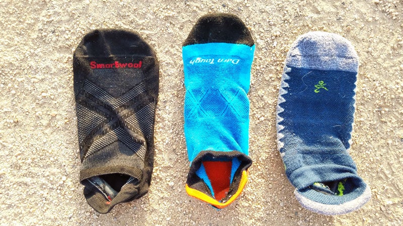 A comparison of the thinnest sock tested, the Smartwool Smartwool PhD Run Ultra Light (left) to the thickest sock, the Bagela Silver (right). The Darn Tough Vertex Ultra-Light Cushion pictured in the center falls just about the middle of the road.