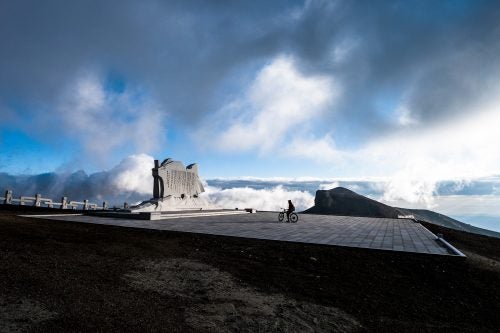 Amidst swirling clouds of a clearing storm, Harald Philipp pauses at the Paektu monument. Bad weather foiled our first attempt to ride on Paektu a day earlier, but a 3:45 a.m. start this day rewarded us with summit success during our short, 48-hour stop over in the north of the country. Few North Koreans get the opportunity to visit Paektu, a sacred mountain, renowned for sudden storms and winter temperatures that drop to -50F.