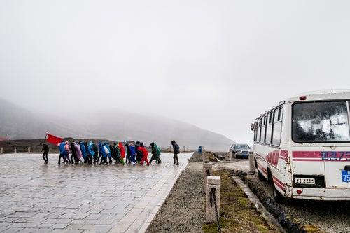 Led by a red flag, a team of workers enjoying their one rest day per week begin a hike up Mount Paektu. While rain and gale force winds dissuaded us from trying to ride Paektu on our first attempt, North Koreans were not so easily deterred. We watched their progress from the chilly but dry interior of our bus.