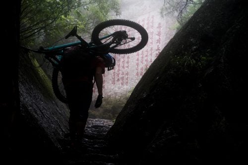 A wall of propaganda slogans looms out of the mist as Max Schumann carries his bike up a steep trail on Mount Myohyang. While we expected to be greeted by political propaganda among Pyongyang’s city streets, such propaganda, hand-chiselled in rock faces, came as a surprise as we explored the forest trails of Mount Myohyang.