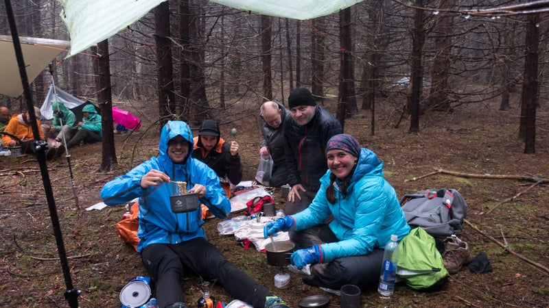 Having dinner together under group tarps