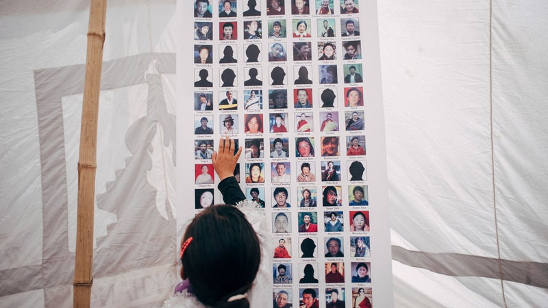 A child touching images of Tibetan self-immolators