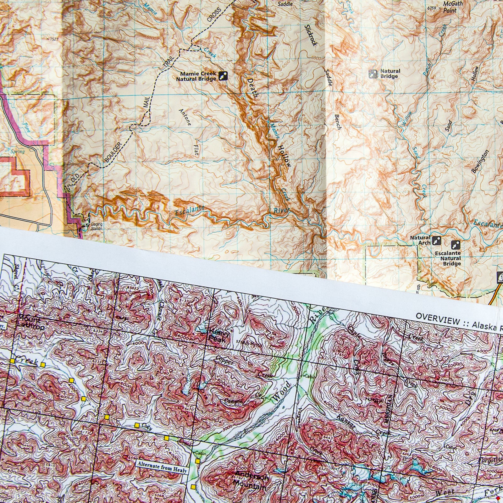 This close-up reveals how much topographic detail is compressed onto these maps. The map of Utah (rear) is at a scale of 1:75,000, or more than one mile per inch; the map of Alaska (front) is 1:250,000, or four miles per inch. These maps are most useful when planning a trip and may be sufficient in the field only for on-trail itineraries.