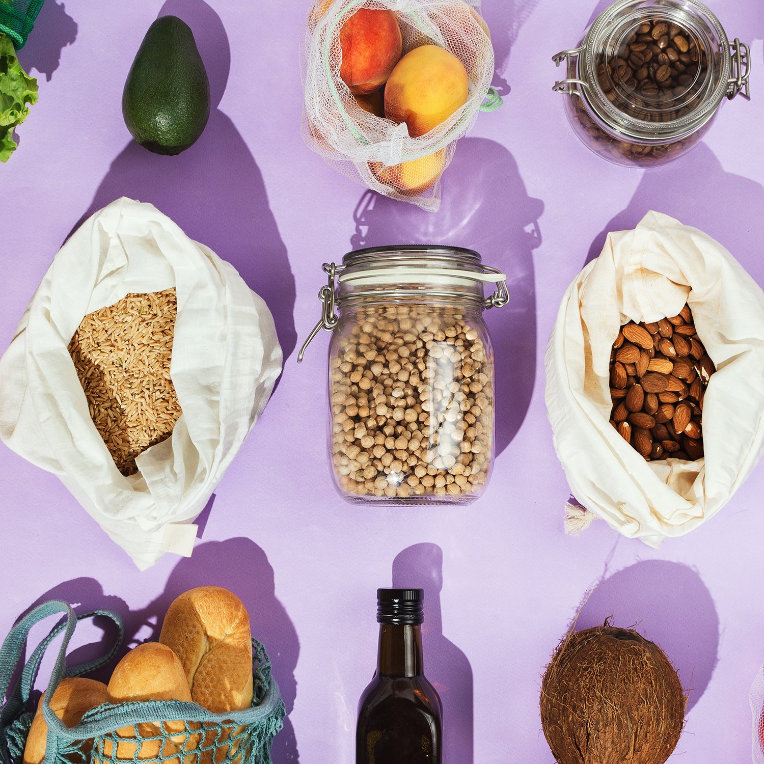 Zero-waste healthy grocery shopping concept: pulses, fruits, greens and vegetables in mesh net or cotton bags and glass jars