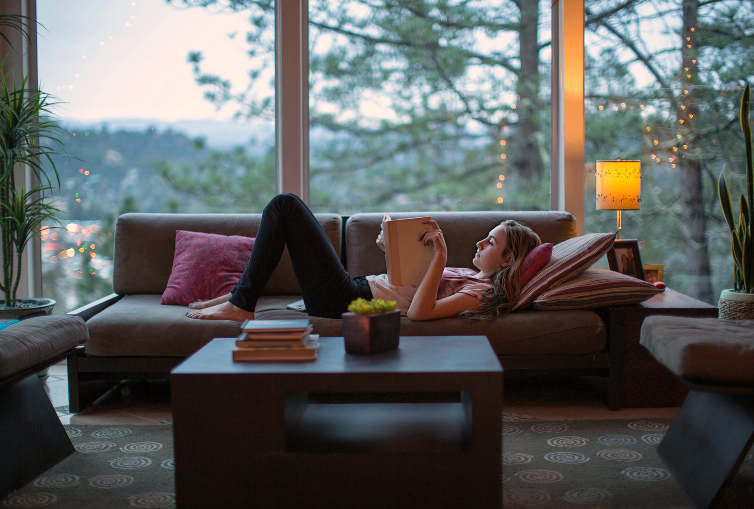 Teenage Girl Reading On The Couch In A Modern Home