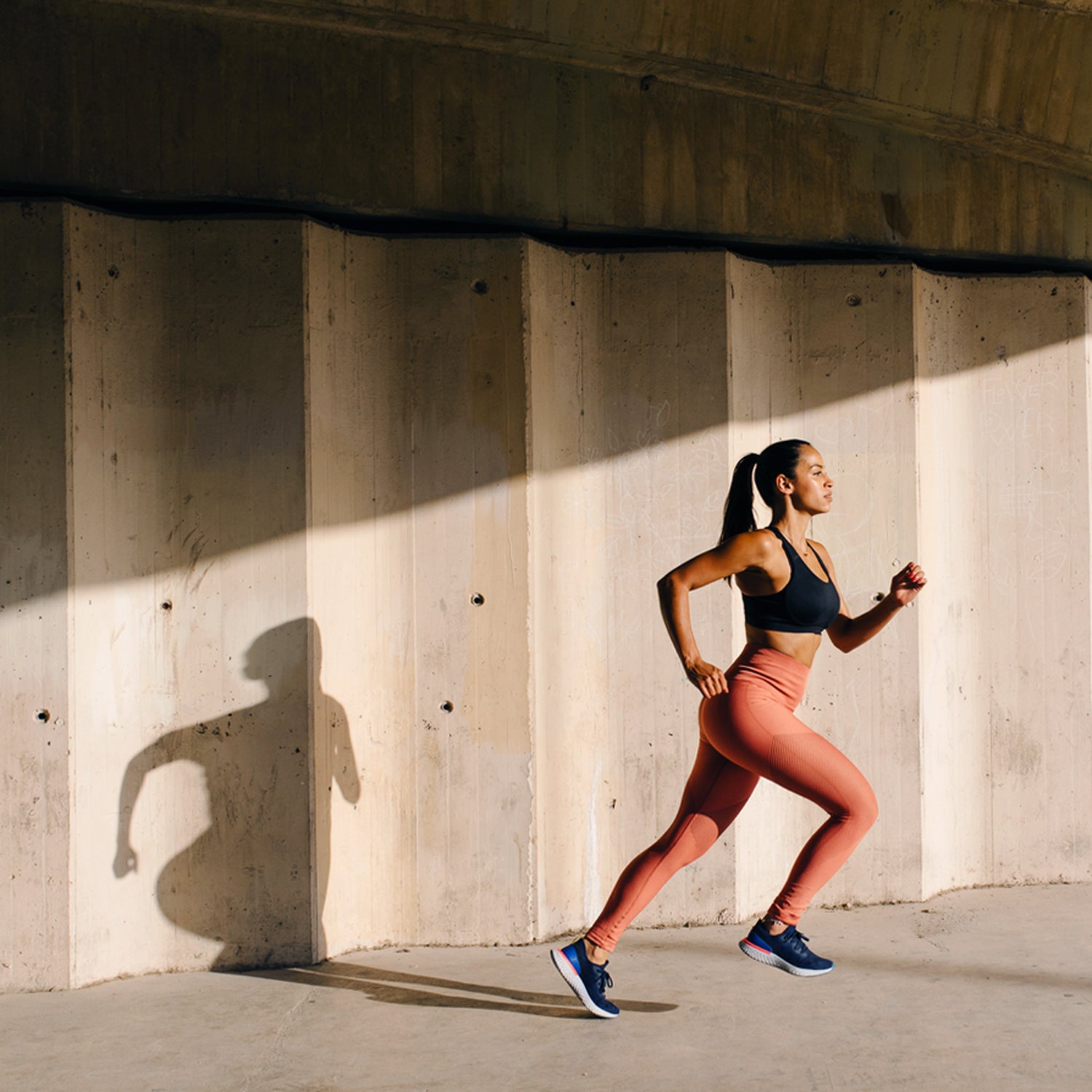 Athletic Woman Running On Street In Sunlight