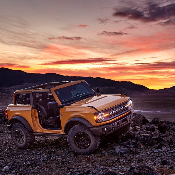 A two-door Bronco with roof and doors removed.