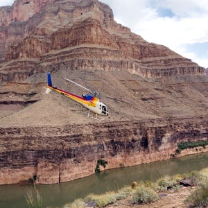 A helicopter in flight between mountains