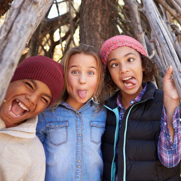 Group Of Children Playing In Forest Camp Together