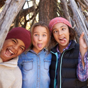 Group Of Children Playing In Forest Camp Together