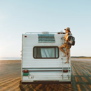 Young girl climbing the top of motorhome