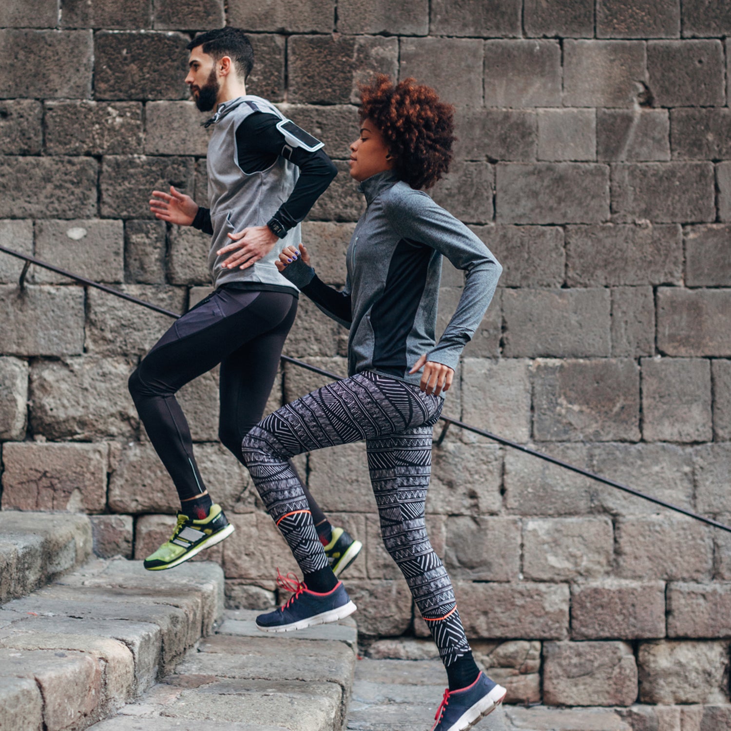 Young Multiethnic Couple Running Of Old Steps Outside.