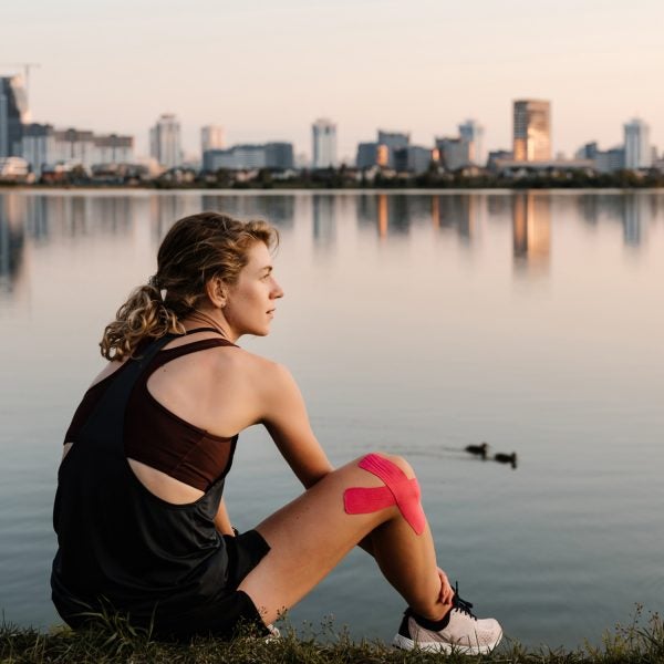 Athletic Young Women Relaxing Next To City Park Lake